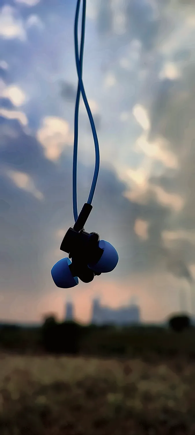 blue earphones hanging against the sky