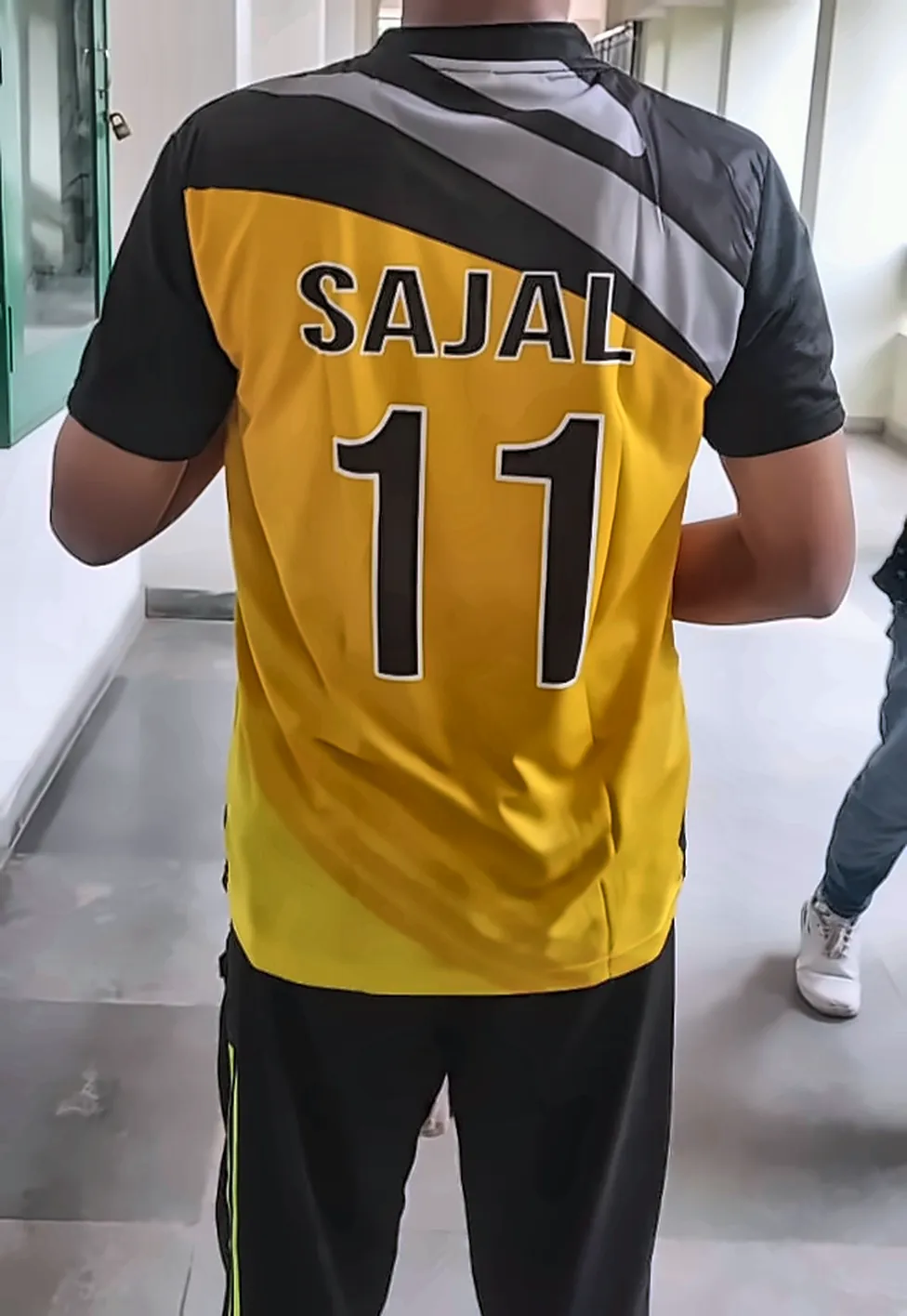 me from behind in a yellow SAJAL 11 jersey