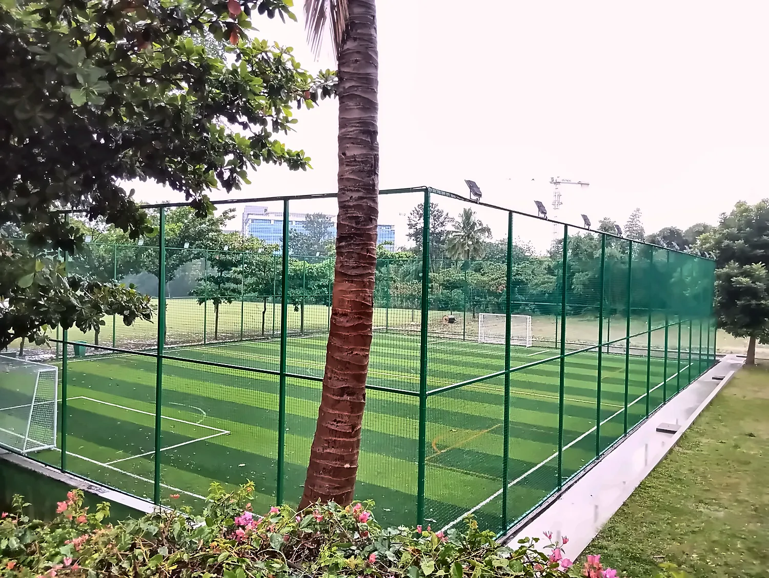 a fenced green turf on a cloudy day
